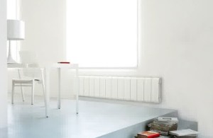 Aluminium Radiators in Agora Collection Long White Radiator in the Family Room with Stacks of Books and White Wooden Table and Chair