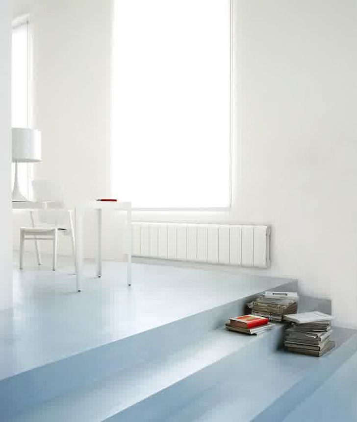 Aluminium Radiators in Agora Collection Long White Radiator in the Family Room with Stacks of Books and White Wooden Table and Chair
