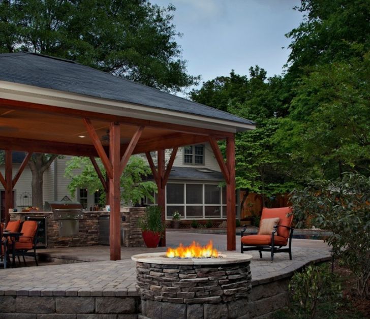 smart patio ideas outdoor-kitchen-with-red-chair-patio-and-stone-fireplace
