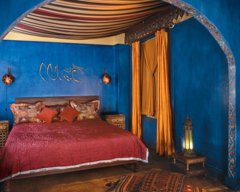 blue bedroom theme with wooden moroccan side table and hardwood headboard
