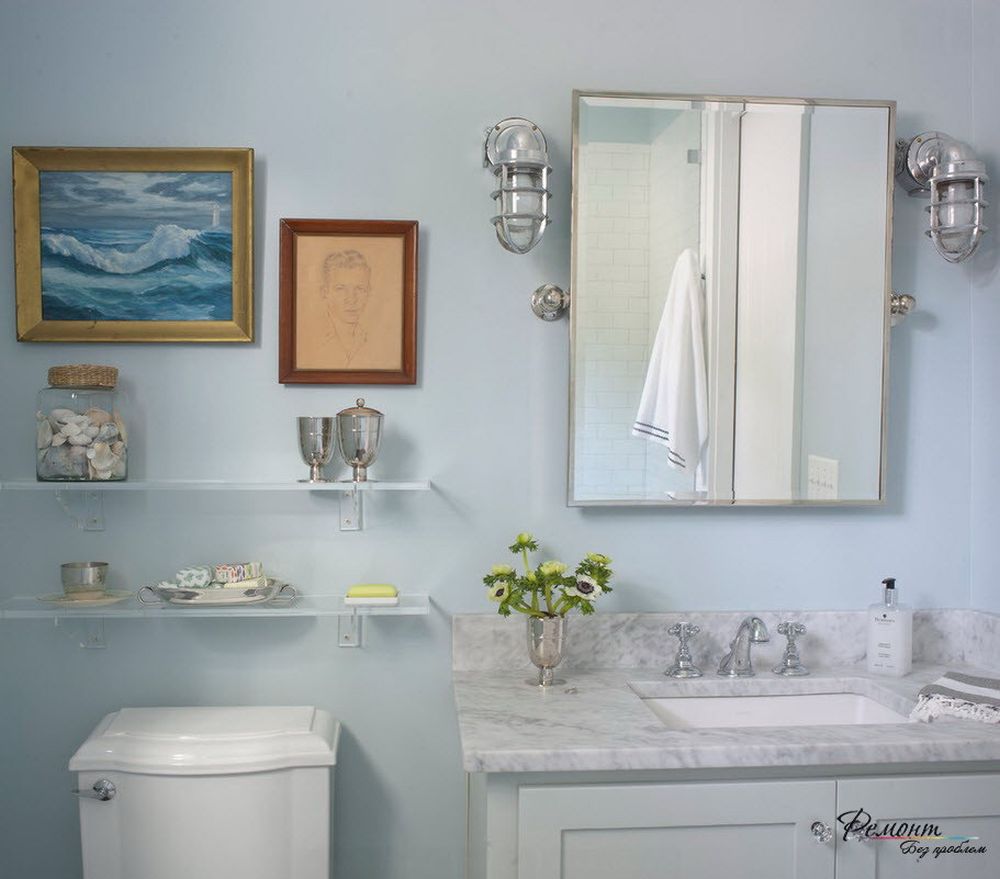 white glass shelves on the light blue wall with framed painting and nautical theme