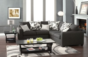dark gray v-shaped sectional sofa with several white patterned throw pillows stylish sectional sofas that work optimally for small spaces